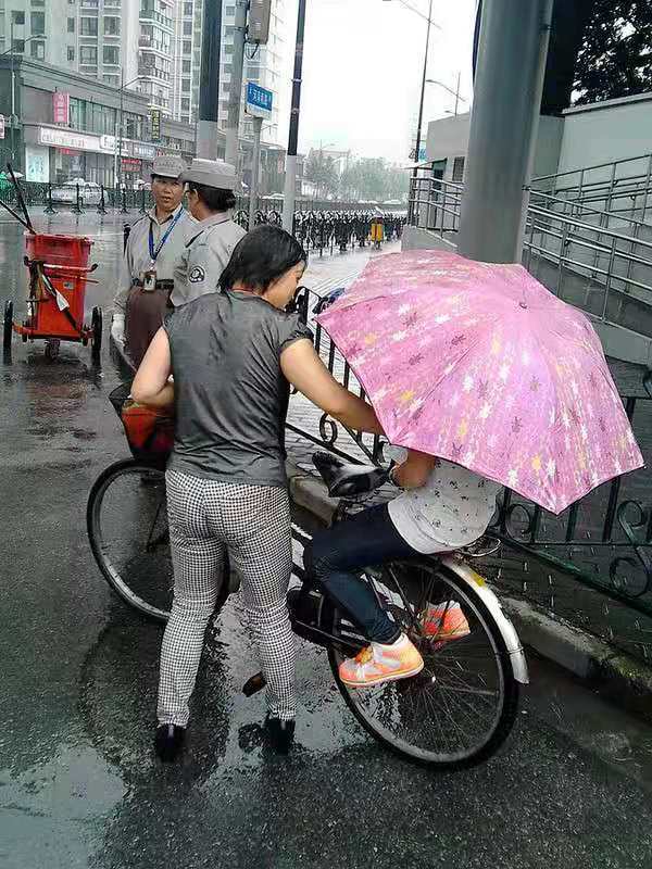 暴风雨中的暖心援助，小伙助女子扶起三轮车